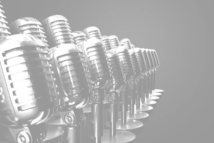 Black and white photo of 1950's style microphones on black background